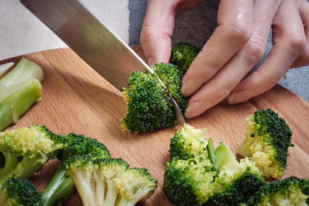 foto cortando brócoli para hacer hamburguesa de brócoli vegana