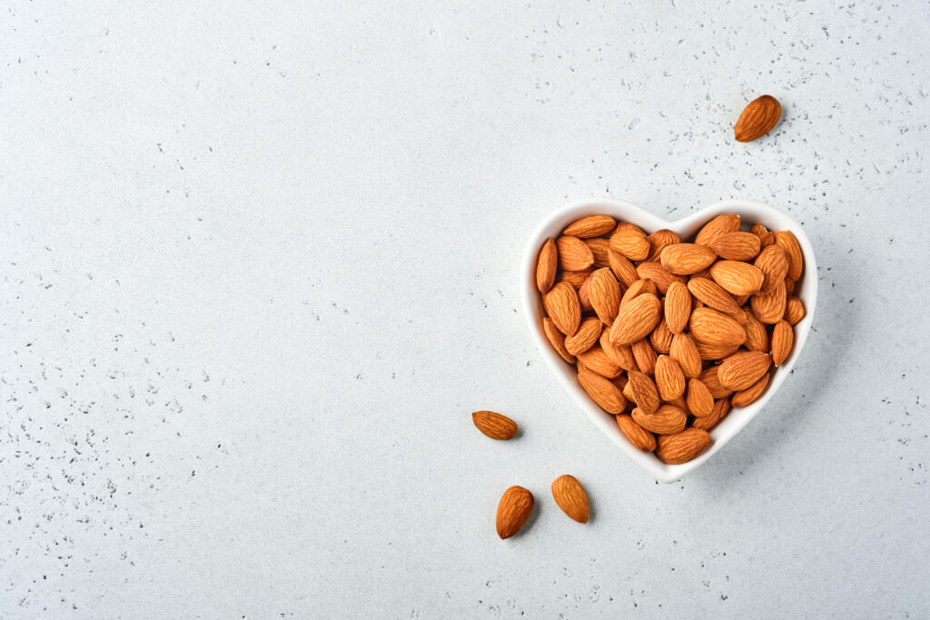 Foto de almendras en un cuenco en forma de corazón para ilustrar el beneficio a nivel de vitaminas de las almendras.